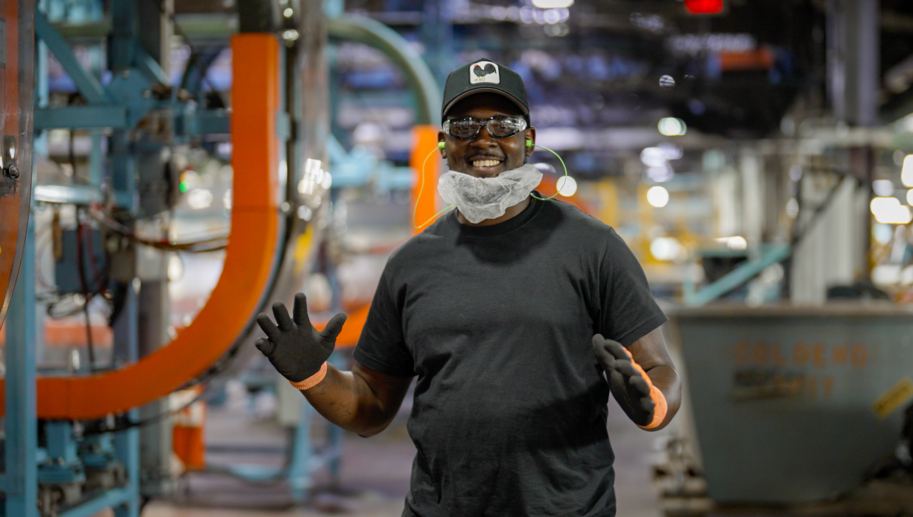 Anchor Glass plant worker in safety glasses and gloves on the production floor